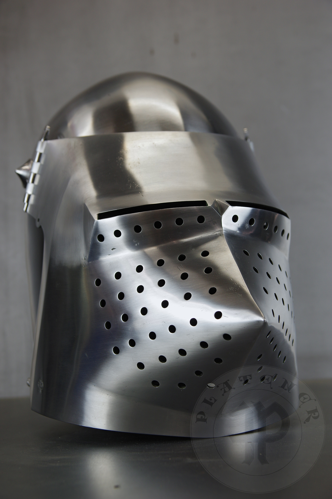 Visored bascinet based on example from Le Landeron in Switzerland, circa 1380-1400. Material: 2 mm steel with 0,3 % carbon. Heat treatment: hardened and tempered up to 34 HRC. Weight 4,090 kg / Przybica starszego typu tzw. psi pysk wzorowana na oryginale z Le Landeron w Szwajcarii, datowana na 1380-1400 rok. Materia: stal 2 mm o zawartoci wgla 0,3%. Hartowany i odpuszczany do 34 HRC. Waga 4,090 kg.
